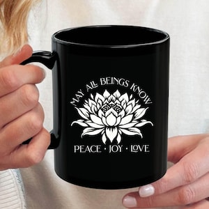 Buddhist mug featuring a lotus and a blessing. Beatiful white design on black mug. Two sizes are available.