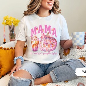 May include: White t-shirt with a pink "MAMA is ready for pumpkin spice" graphic featuring a pumpkin and a fall-themed drink.
