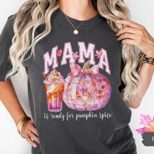 May include: A dark gray t-shirt with the text "MAMA is ready for pumpkin spice" in white. The shirt features a pink and white watercolor pumpkin with a pink bow and a pink and orange watercolor iced coffee.