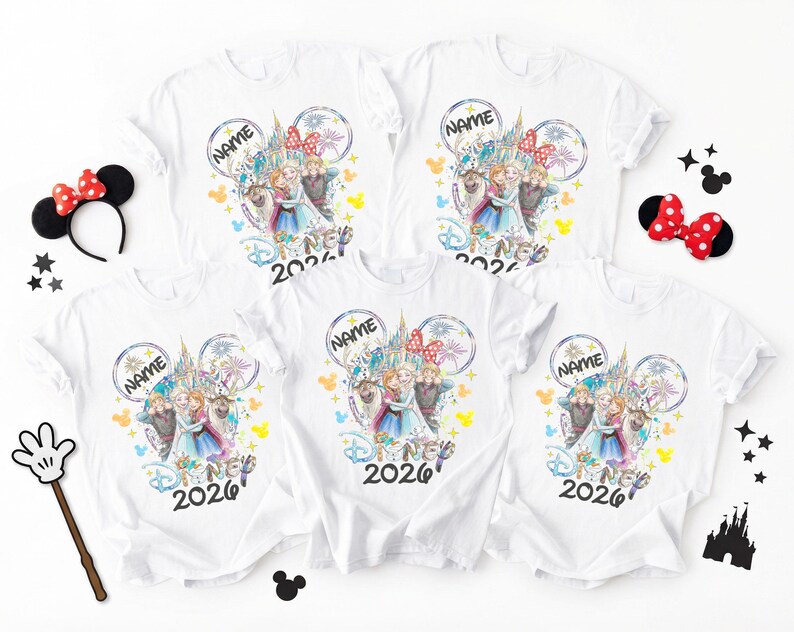 May include: White t-shirts with a colorful Disney-themed graphic featuring characters and a castle design. The shirts include the text "NAME" and "2026". Accessories include a Minnie Mouse ear headband, a bow, a wand, and Mickey Mouse silhouettes.