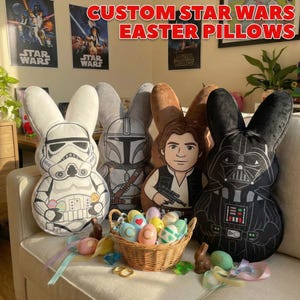 May include: Custom Star Wars Easter pillows in the shape of bunnies. The pillows feature characters like Darth Vader, Stormtrooper, and Han Solo. A wicker basket holds decorated Easter eggs. The text "CUSTOM STAR WARS EASTER PILLOWS" is at the top.