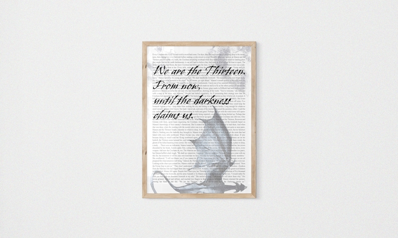 May include: A framed print with a black and white image of a dragon with the text "We are the thirteen. From now, until the darkness claims us."