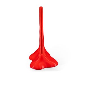 May include: A bright red plastic shoe stand with a tall, narrow, vertical design. The stand has a wide, flat base with a rounded, heart-shaped design.
