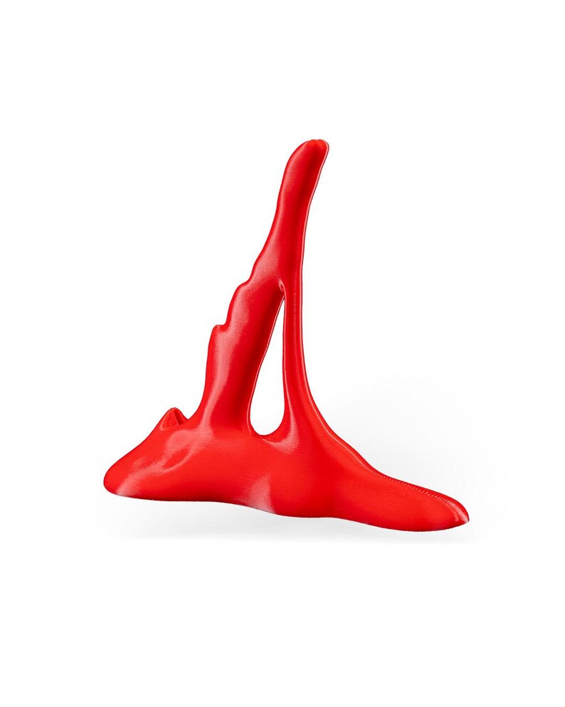 May include: A bright red abstract sculpture made of a smooth, glossy material. The sculpture is shaped like a tall, thin tower with a wide base.
