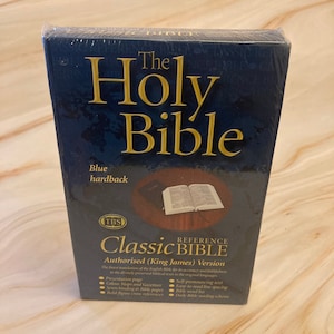 May include: A blue hardback book with the title "The Holy Bible" and the subtitle "Classic Reference Bible Authorised (King James) Version". The book cover features a gold embossed design and a small image of an open Bible.