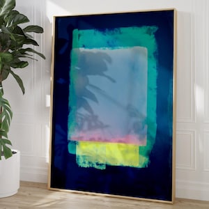 Könnte beinhalten: Abstrakter Kunstdruck mit dunkelblauem Hintergrund und goldenem Rahmen. Das Kunstwerk zeigt sich überlappende rechteckige Formen in Blau-, Grün-, Rosa- und Gelbtönen. Der Druck wird vor einer weißen Wand mit einer Topfpflanze präsentiert.