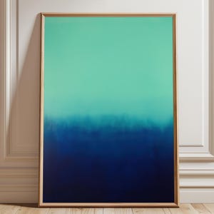 May include: Framed abstract art print. The artwork showcases a colour gradient, starting with a light teal at the top and fading into a deep navy blue at the bottom. The painting is displayed against a white wall and wooden floor.