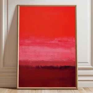 Könnte beinhalten: Gerahmter Kunstdruck mit abstrakter Kunst. Das Kunstwerk zeigt einen Farbverlauf aus Rottönen, der von einem tiefen Purpurrot am unteren Rand zu einem leuchtenden Rot am oberen Rand übergeht. Ein Band aus Rosa und Weiß sorgt für Kontrast.