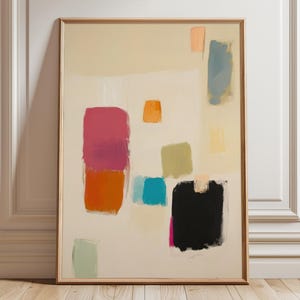 Könnte beinhalten: Abstrakter Kunstdruck in einem Holzrahmen. Das Kunstwerk zeigt farbenfrohe, geometrische Formen in den Farbtönen Rosa, Orange, Blau, Grün und Schwarz vor einem cremefarbenen Hintergrund. Das Gemälde wird vor einer weißen Wand und einem Holzboden ausgestellt.