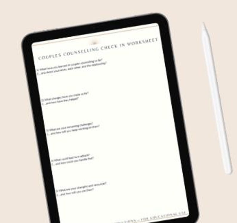 K&ouml;nnte beinhalten: Ein digitales Tablet, das ein "Paarberatungs-Check-in-Arbeitsblatt" mit Fragen zu Beziehungen anzeigt. Ein wei&szlig;er Stift liegt neben dem Tablet auf einer hellbeige Oberfl&auml;che. Der Bildschirm des Tablets ist mit Text gef&uuml;llt.
