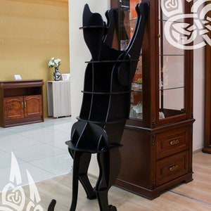 Puede incluir: Estantería en forma de gato negro con múltiples estantes. La estantería está hecha de madera y tiene un diseño moderno.