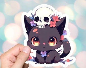 May include: A black cat with a skull on its head and flowers around its neck. The cat has large, bright yellow eyes and a cute expression.