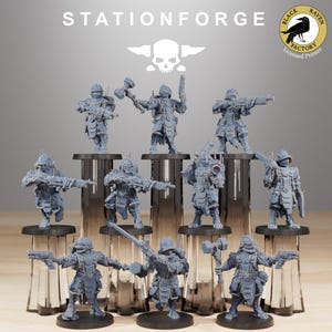 Op de afbeelding: Een set van 12 grijze plastic miniatuurfiguurtjes van soldaten, elk met een ander wapen in de hand, staand op ronde bases. De figuurtjes zijn gerangschikt in twee rijen van zes, waarbij de voorste rij iets verschoven is ten opzichte van de achterste rij. De figuurtjes dragen allemaal een harnas en een helm. De figuurtjes zijn allemaal naar voren gericht. De figuurtjes staan allemaal op een houten oppervlak. De figuurtjes maken allemaal deel uit van een set miniatuurfiguurtjes voor een tabletop-spel. De figuurtjes zijn allemaal van de Stationforge Black Raven Factory.