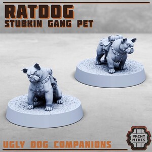 Op de afbeelding: Twee 3D-geprinte miniatuurfiguren van bulldogachtige wezens met rugzakken, met de tekst "Ratdog Stubkin Gang Pet" en "Ugly Dog Companions".