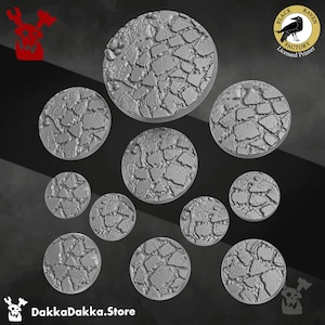 Op de afbeelding: Een set van 10 ronde, grijze, hars, getextureerde, gebarsten, steenachtige bases voor miniature wargaming. De bases zijn in verschillende maten. De bases zijn gemaakt door Black Raven Factory, een gelicentieerde printer.