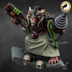 Può includere: Una creatura simile a un ratto, di colore verde e marrone, che indossa un elmo di metallo e tiene una pistola verde e nera. La creatura è in piedi su una base di roccia con tre teschi. La creatura indossa una tunica verde e marrone e ha un trapano sul braccio destro. L'immagine è di Black Raven Factory, una stampante autorizzata.