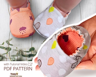 May include: A pair of soft baby shoes featuring an orange fabric with purple stars and rain clouds, and a grey fabric with colourful teardrop shapes. The interior of the shoes is lined with orange fabric. Text reads: with Tutorial Video PDF PATTERN THUY SEWING PATTERN.