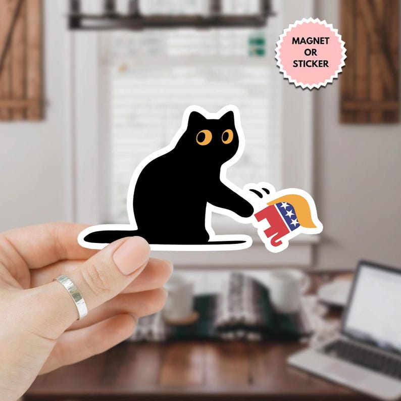 K&ouml;nnte beinhalten: Eine schwarze Katze mit gelben Augen schl&auml;gt nach einem rot-wei&szlig;-blauen Elefanten mit einem gelben Hut. Der Elefant ist ein politisches Symbol.