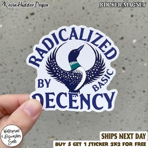 May include: A white sticker with a stylized loon illustration, wings spread, and the words "RADICALIZED BY DECENCY" in a dark blue font. The sticker is labeled "STICKER/MAGNET" and includes text about being waterproof and dishwasher safe.