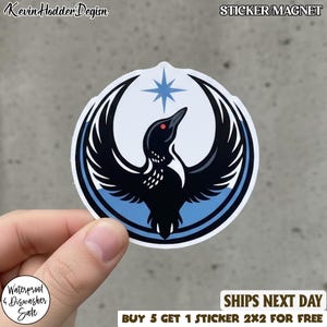 May include: A round sticker or magnet featuring a stylized black bird with outstretched wings, a red eye, and a blue star on a light blue and white background. The text "STICKER/MAGNET" is at the top. The sticker is waterproof and dishwasher safe.