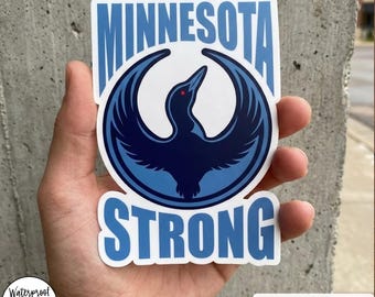 Puede incluir: Una pegatina o imán con las palabras "MINNESOTA STRONG" en azul claro. El diseño incluye un emblema de pájaro azul oscuro con un ojo rojo. El texto "STICKER/MAGNET" está en la parte superior. La pegatina es impermeable y apta para lavavajillas.