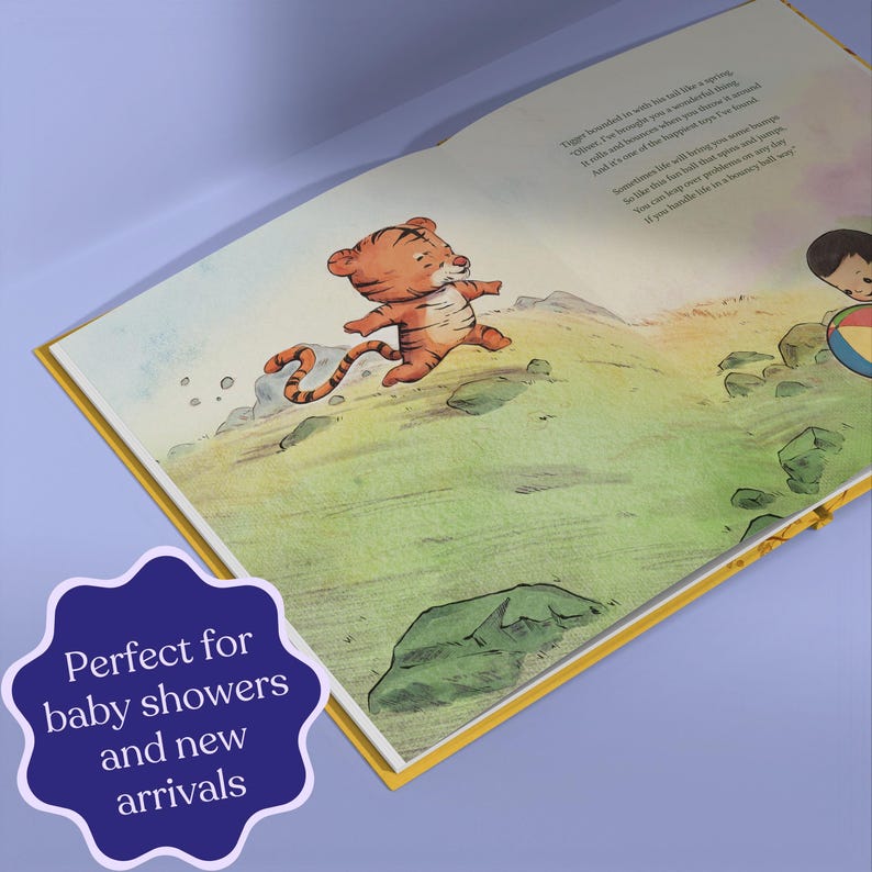 Pode incluir: Livro aberto com uma ilustra&ccedil;&atilde;o colorida de um tigre de desenho animado correndo em uma colina verde. O texto na p&aacute;gina &eacute; parcialmente vis&iacute;vel. Um adesivo roxo na parte inferior diz "Perfeito para ch&aacute;s de beb&ecirc; e novidades".