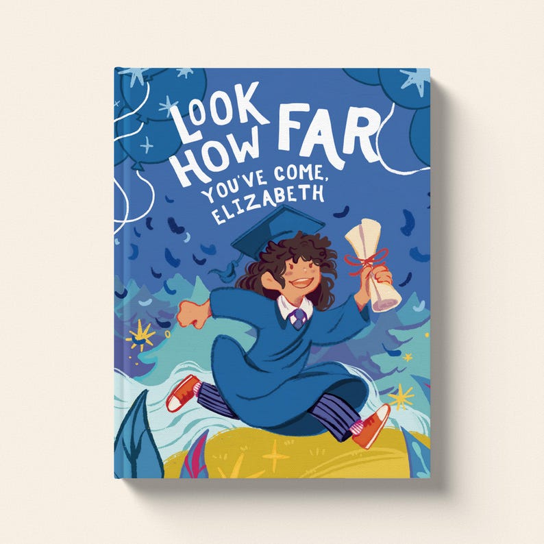 Op de afbeelding: Een blauwe boekomslag met de tekst "Look How Far You've Come, Elizabeth" in wit. De omslag toont een illustratie van een persoon in een blauwe afstudeerjurk en een pet, die een diploma vasthoudt en naar een geel veld met groene bomen en blauwe wolken op de achtergrond rent.