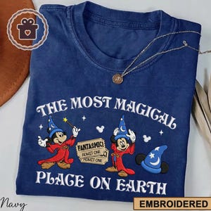 May include: A white ceramic mug with a black handle and the text "But First, Coffee" in a black, handwritten-style font. The mug is on a white surface.