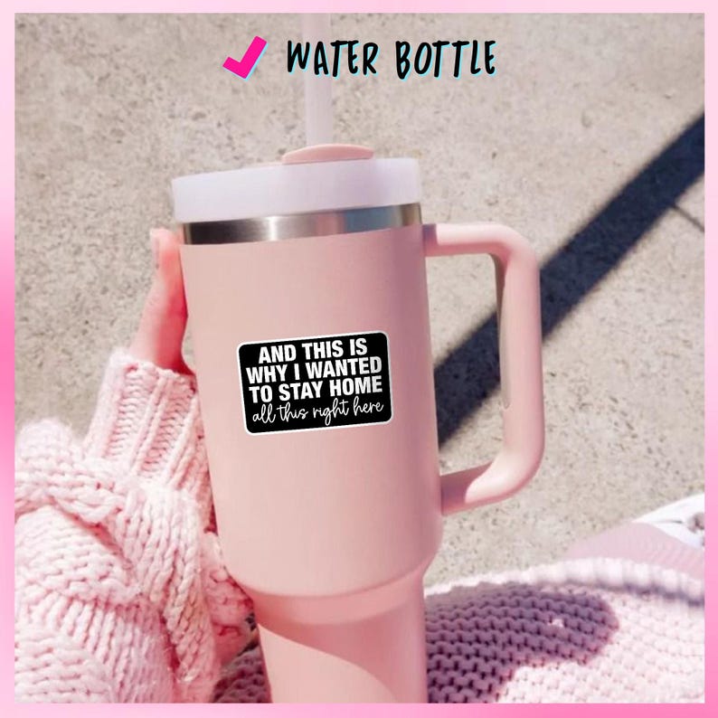 May include: A large, pink water bottle with a white lid and handle. A black sticker on the bottle reads "AND THIS IS WHY I WANTED TO STAY HOME all this right here". The text "WATER BOTTLE" is above the bottle.