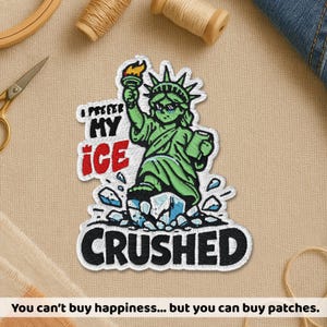 May include: Embroidered patch featuring the Statue of Liberty in green, holding a torch and a tablet, with the text "I prefer my ice crushed." The patch has a white border and is on a beige background. The text "You can't buy happiness... but you can buy patches" is at the bottom.