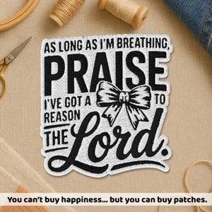 May include: Embroidered patch with the words "AS LONG AS I'M BREATHING, PRAISE I'VE GOT A REASON TO THE Lord." in black and white. A bow graphic is in the center. The text "You can't buy happiness... but you can buy patches." is at the bottom.