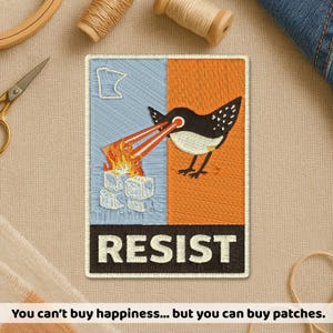 May include: Embroidered patch with a bird shooting laser beams at ice cubes and fire. The patch is divided into blue and orange sections, with the word "RESIST" at the bottom. A Minnesota outline is in the blue section.