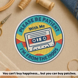 May include: Embroidered patch with the text "PLEASE BE PATIENT With Me I'M FROM THE 1900S" and a cassette tape design. The patch features a yellow, blue, red, and white color scheme. The patch is round.
