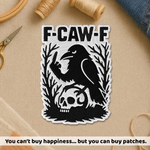 May include: Embroidered patch with the text "F-CAW-F" above a black raven giving the middle finger, perched on a skull. The patch is white with black details. The text at the bottom reads "You can't buy happiness... but you can buy patches."
