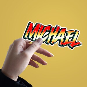 May include: A colorful sticker with the name "MICHAEL" written in a bold, stylized font. The sticker has a red, orange, yellow, and green gradient.