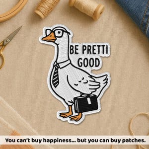 May include: Embroidered patch featuring a goose wearing glasses, a tie, and carrying a briefcase. The patch reads "BE PRETTI GOOD" in black text. The patch is white with black outlines and orange accents.