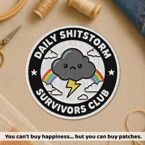May include: Embroidered patch with the text "DAILY SHITSTORM SURVIVORS CLUB". The patch features a sad gray cloud, a rainbow, and a yellow lightning bolt. The text "You can't buy happiness... but you can buy patches" is at the bottom.
