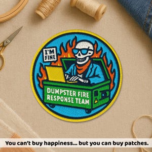 May include: Round embroidered patch with a skull wearing sunglasses, seated in a green dumpster, working on a laptop. The patch reads "I'M FINE" and "DUMPSTER FIRE RESPONSE TEAM" with flames in the background.