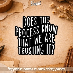 May include: A black sticker with white text that reads "DOES THE PROCESS KNOW THAT WE ARE TRUSTING IT?" The sticker is on a tan background with the text "Happiness comes in small sticky pieces" at the bottom.