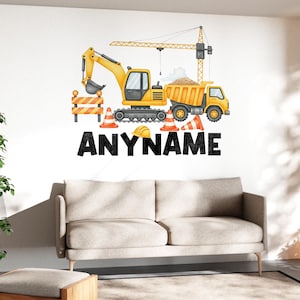 May include: A wall decal featuring construction vehicles, including a yellow excavator, dump truck, and crane. Orange and white traffic cones and a construction barrier are also present. The word "ANYNAME" is displayed in bold, black letters.