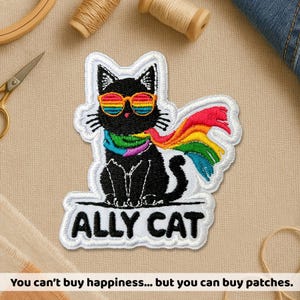 May include: Embroidered patch featuring a black cat wearing rainbow sunglasses and a rainbow scarf. The patch reads "ALLY CAT" in white text. The phrase "You can't buy happiness... but you can buy patches" is at the bottom.