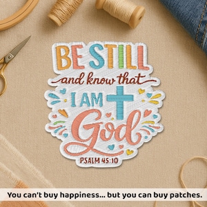 May include: Embroidered patch with the text "BE STILL and know that I AM God" and "PSALM 45:10". The patch features a cross and decorative elements in various colors. The patch is surrounded by a white border.