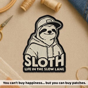 May include: Embroidered patch featuring a smiling sloth wearing a hoodie and a cap. The patch has the word "SLOTH" and the phrase "LIFE IN THE SLOW LANE" in white lettering. The patch is black and white. The text "You can't buy happiness... but you can buy patches" is at the bottom.