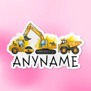 May include: A sticker featuring three yellow construction vehicles: a front-end loader, an excavator, and a dump truck. The word "ANYNAME" is printed in black below the vehicles. The background is a light pink.