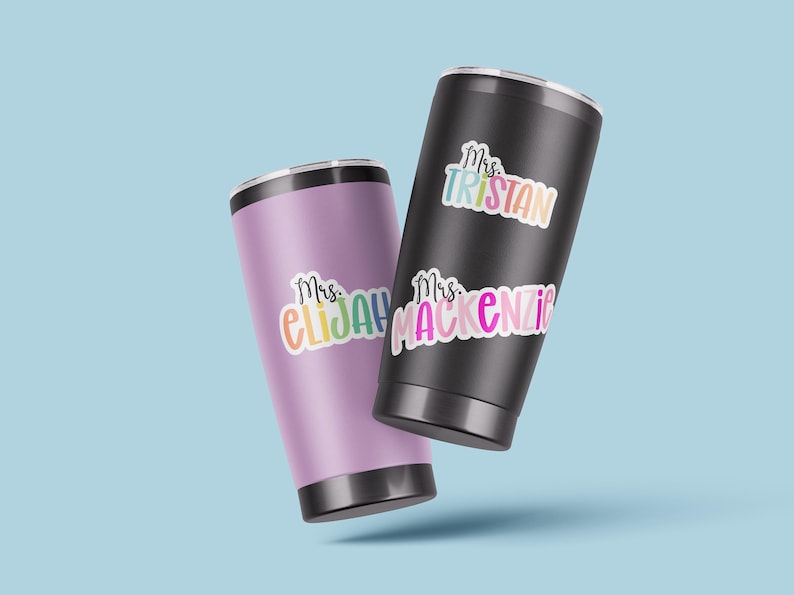 K&ouml;nnte beinhalten: Zwei Edelstahlbecher mit bunten Vinyl-Aufklebern. Die Aufkleber sagen "Mrs. Tristan" und "Mrs. Mackenzie".