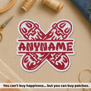 May include: Red and white embroidered patch in a unique shape with the word "ANYNAME" in the center. The patch has a decorative design and is likely for clothing or accessories.