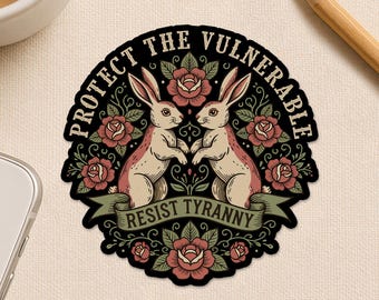 May include: A sticker with a black border features two rabbits facing each other, surrounded by roses. The text "PROTECT THE VULNERABLE" arches above the rabbits, and "RESIST TYRANNY" is on a banner below. The sticker also has the text "Happiness comes in small sticky pieces."