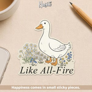 May include: A sticker featuring a white duck with an orange beak and feet, standing in a field of daisies and blue flowers. The text "Like All-Fire" is below the duck. The sticker also has the text "Happiness comes in small sticky pieces."