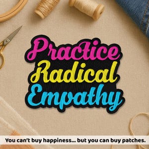 May include: Embroidered patch with the words "Practice Radical Empathy" in pink, yellow, and blue on a black background. The patch is surrounded by sewing supplies, including scissors and thread spools. The text at the bottom says "You can't buy happiness... but you can buy patches."
