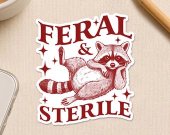 May include: A red and white sticker featuring a relaxed raccoon illustration with the words "FERAL & STERILE". The sticker also includes the text "Happiness comes in small sticky pieces."